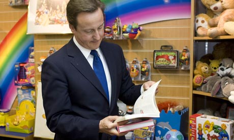 David Cameron flicking through books in a holiday shop