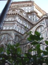 The dome and apse of Florence Cathedral seen through the foliage around the Bottegha di Donatello